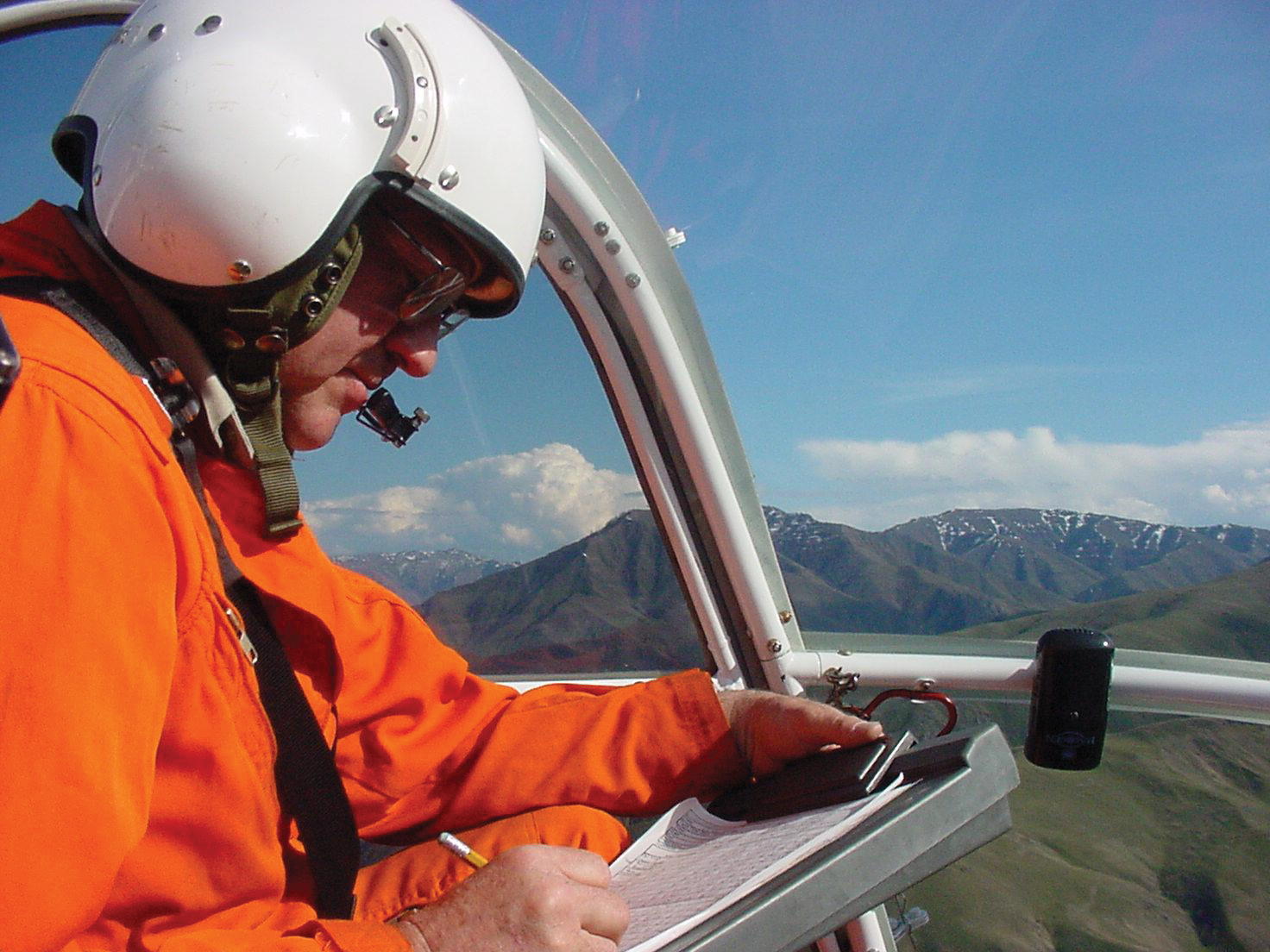 researcher in a helicopter taking notes March 2001