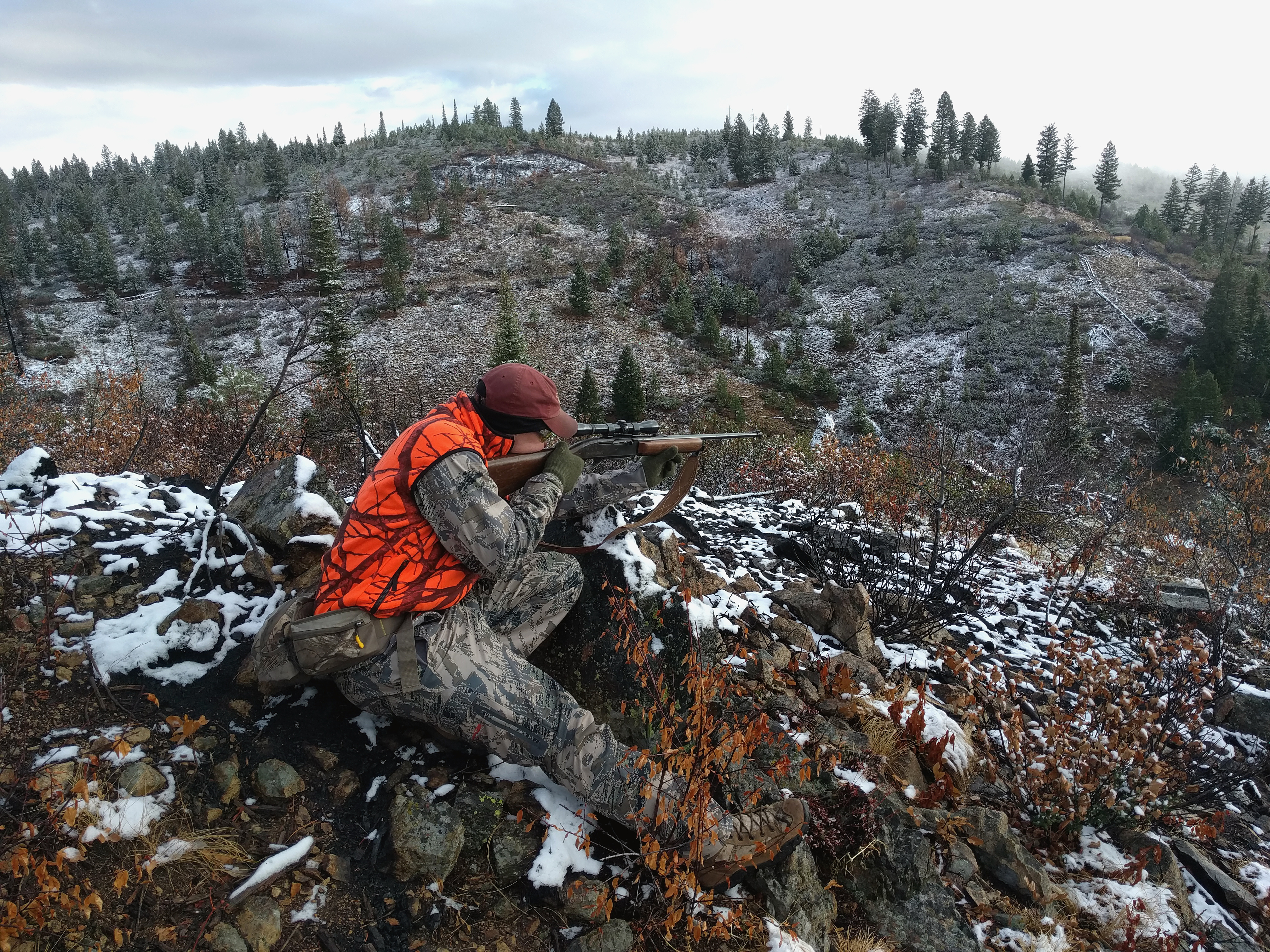 big game hunter dressed in hunter orange taking aim at an animal with his rifle Ben Studer wide shot, November 2016