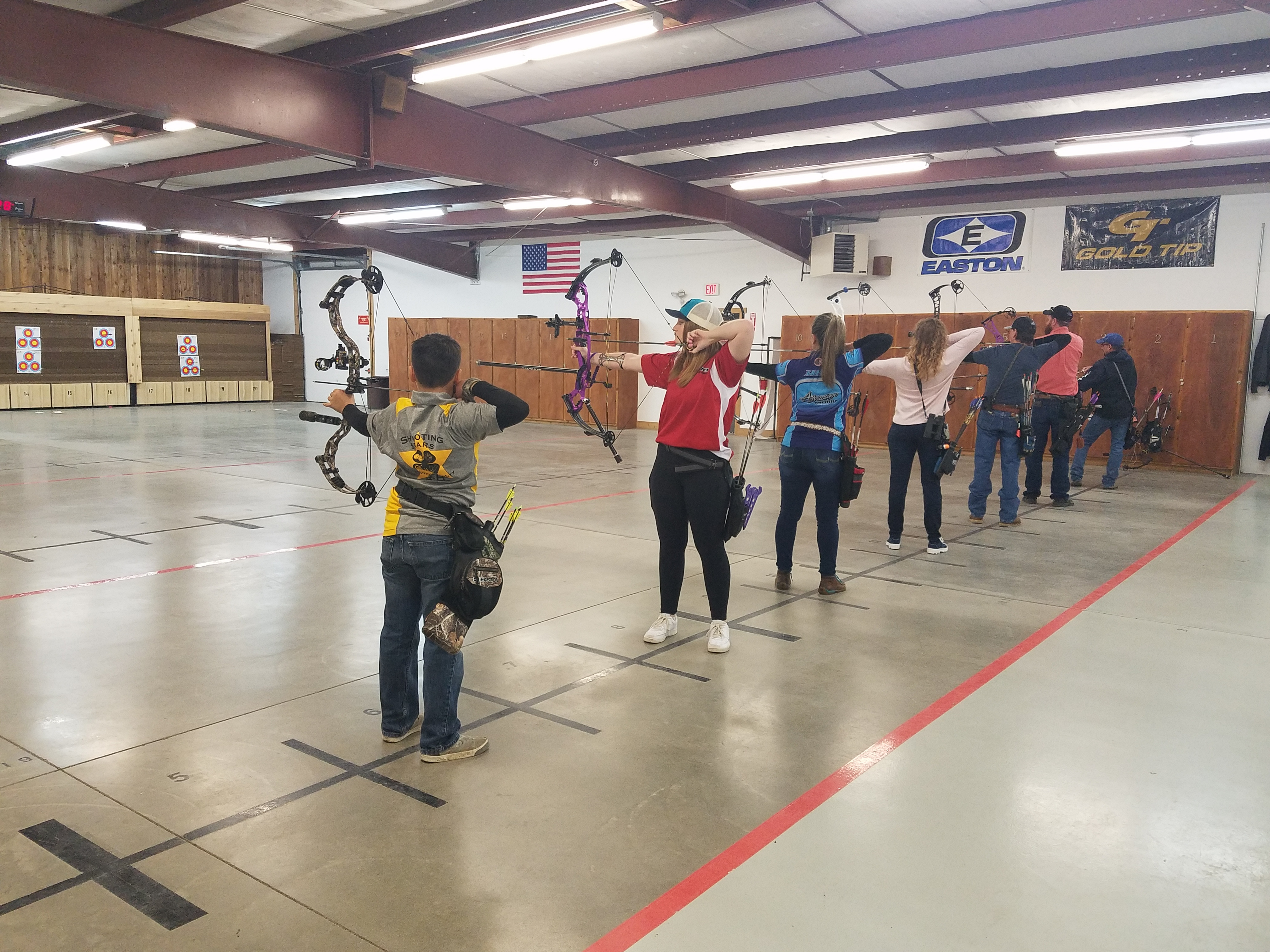 Seven archers draw their bows at the Nampa Public Shooting Range