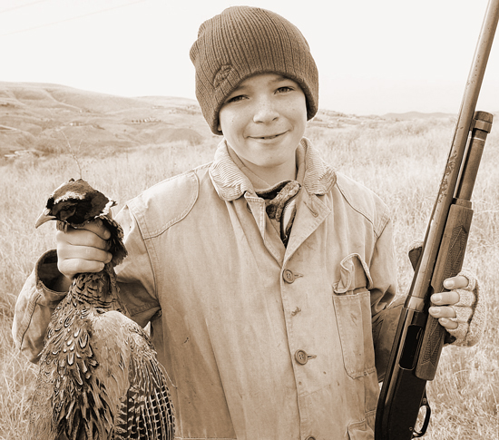 Young boy with rooster pheasant