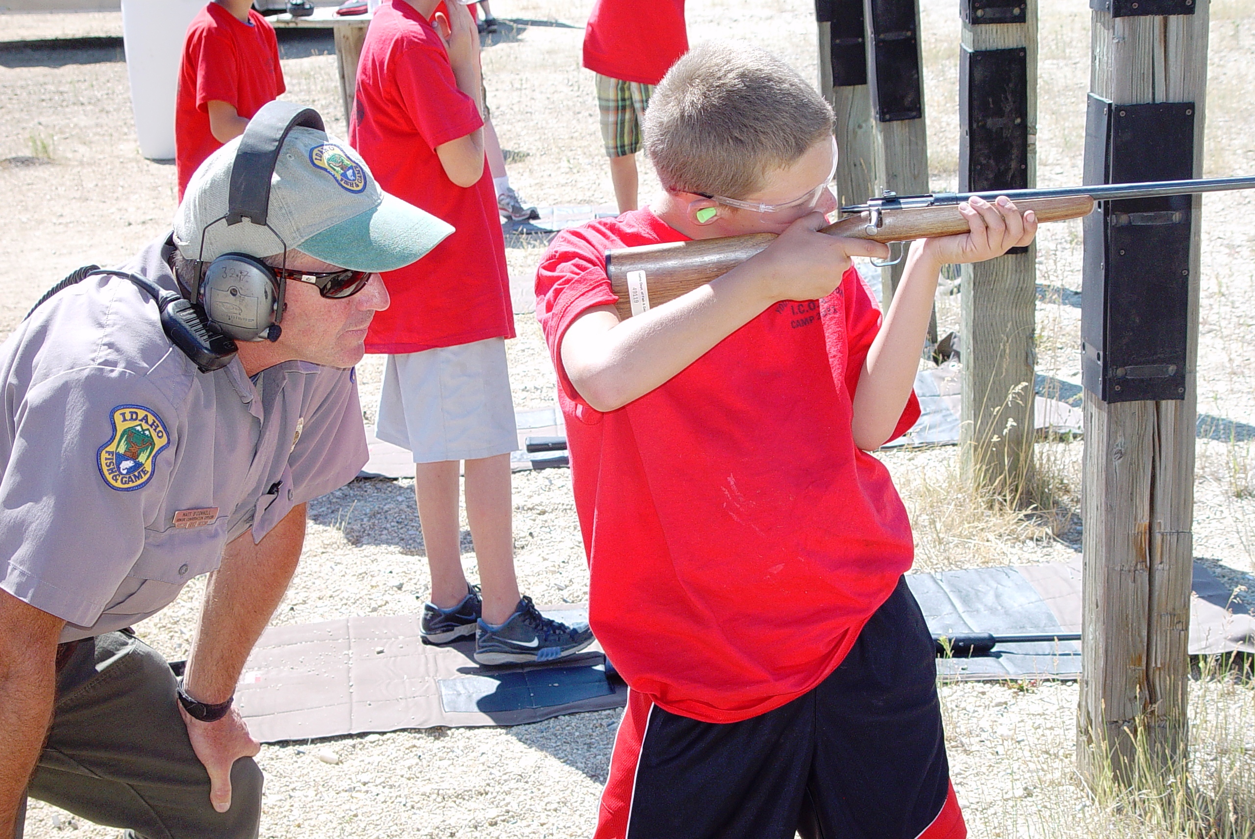 IDFG Conservation Officer Matt O'Connell watches as a boy aims his rifle at a Hunter Education class August 2011