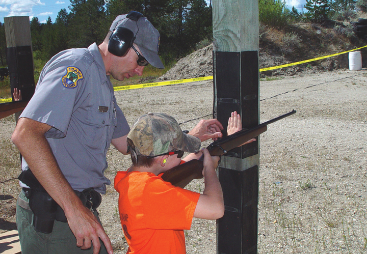 an IDFG  conservation officer instructs a boy how to use a rifle during a hunter Education class August 2010