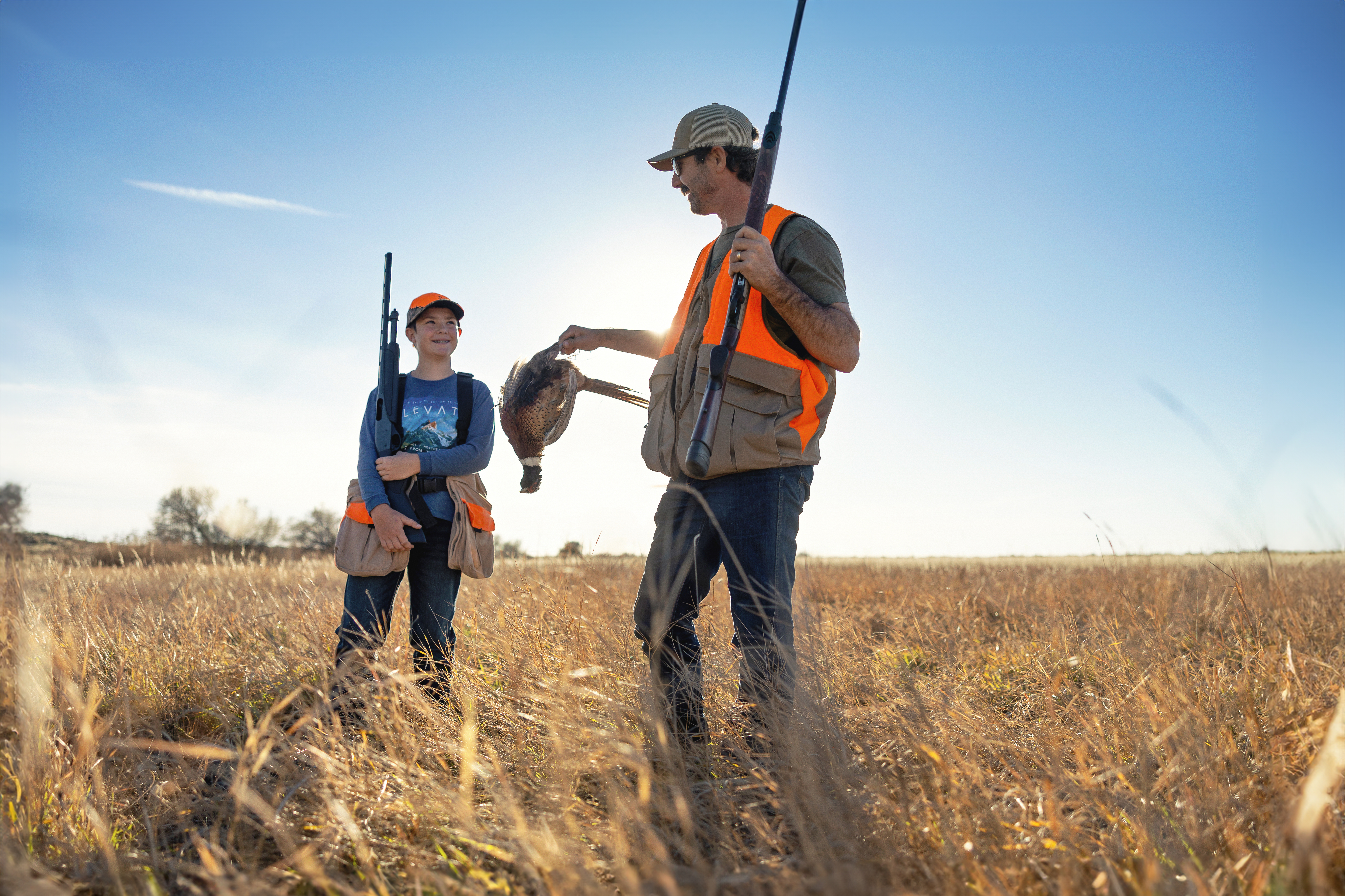 Youth hunter and dad shooting a pheasant in the Magic Valley Region