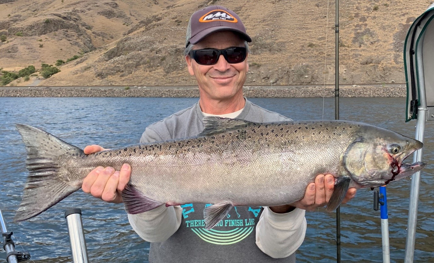 Angler holding a fall Chinook caught in the confluence area