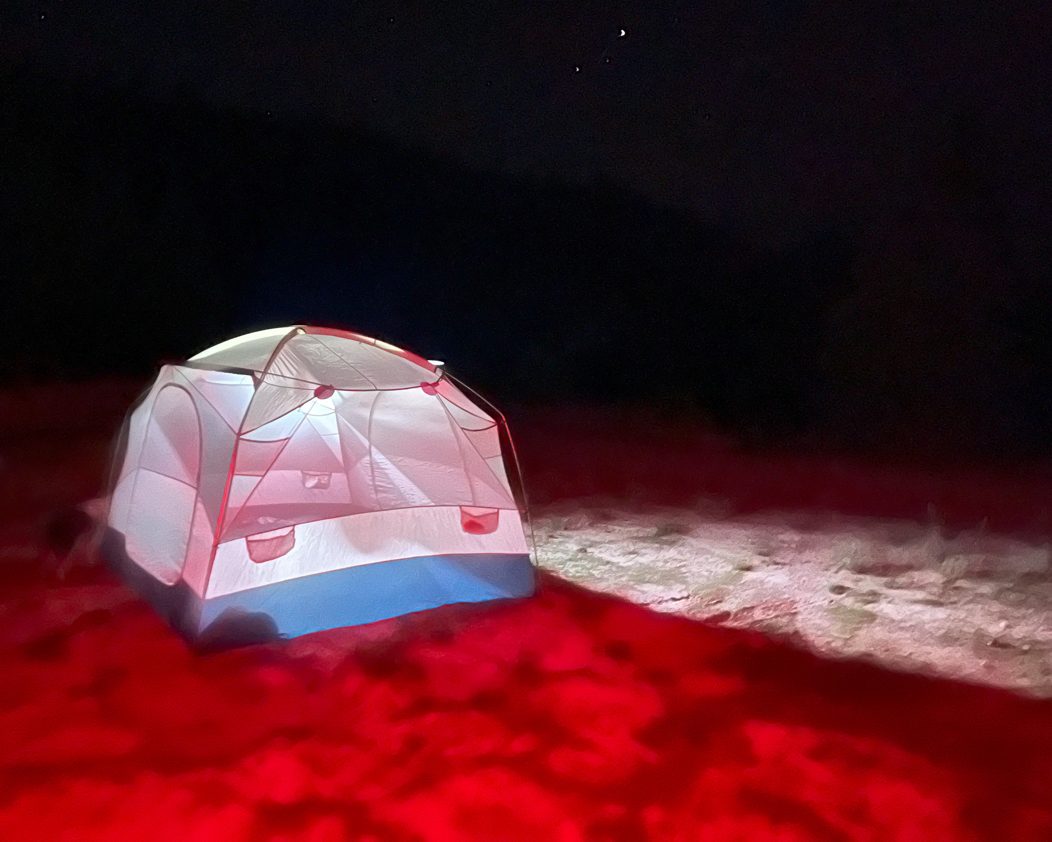 Hunter's tent lit up with headlamps and lanterns late at night_PC Connor Jay Liess