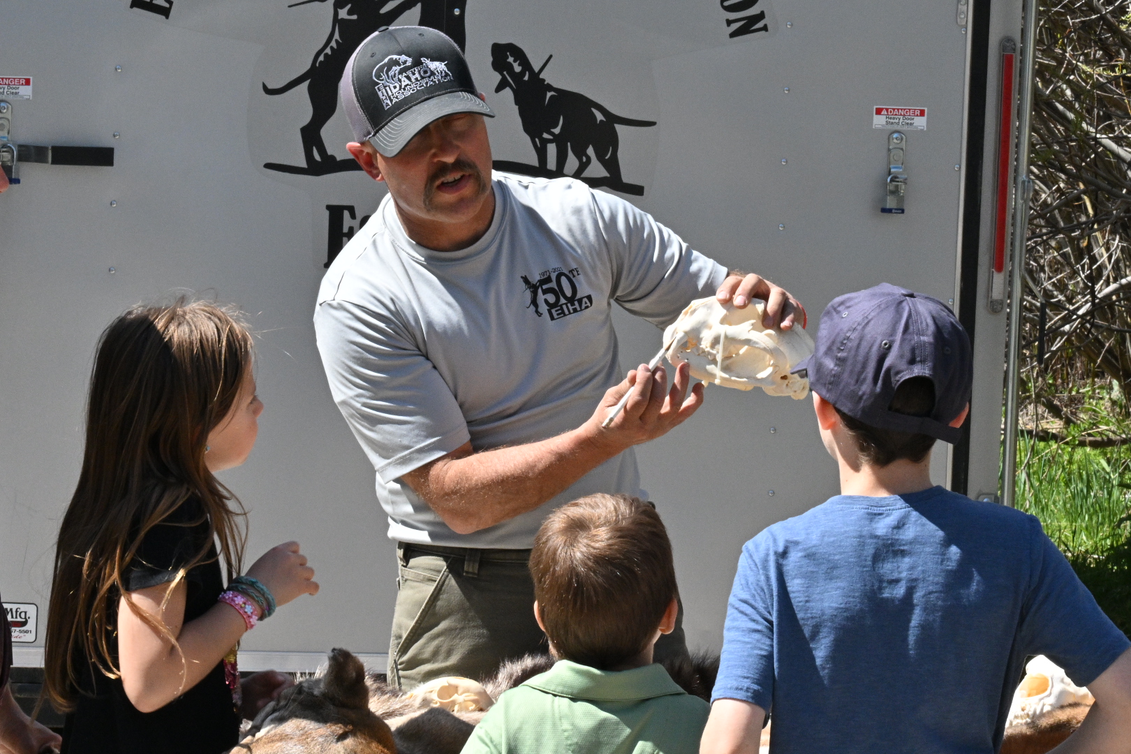 Man showing a mountain lion skull to youth 