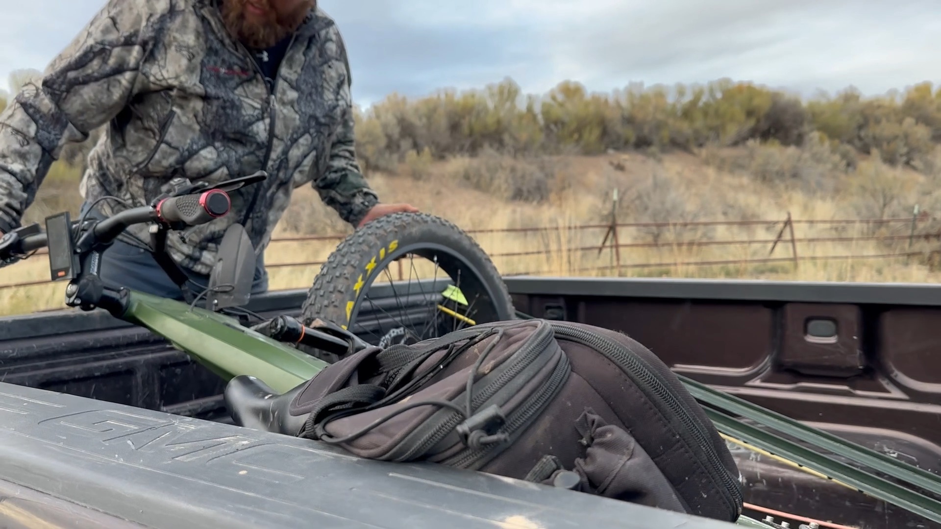 A hunter loading an electric bike into the bed of a pickup.