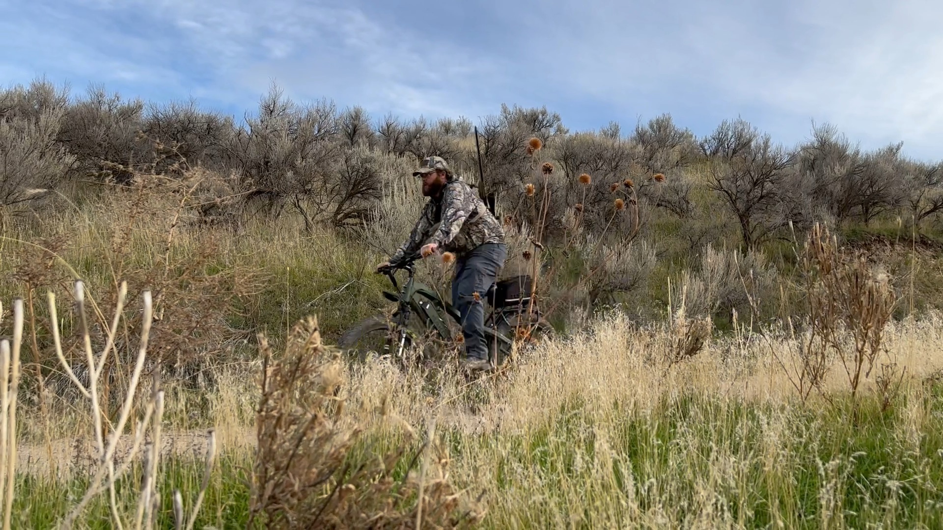 A hunter riding an electric bike on a trail.
