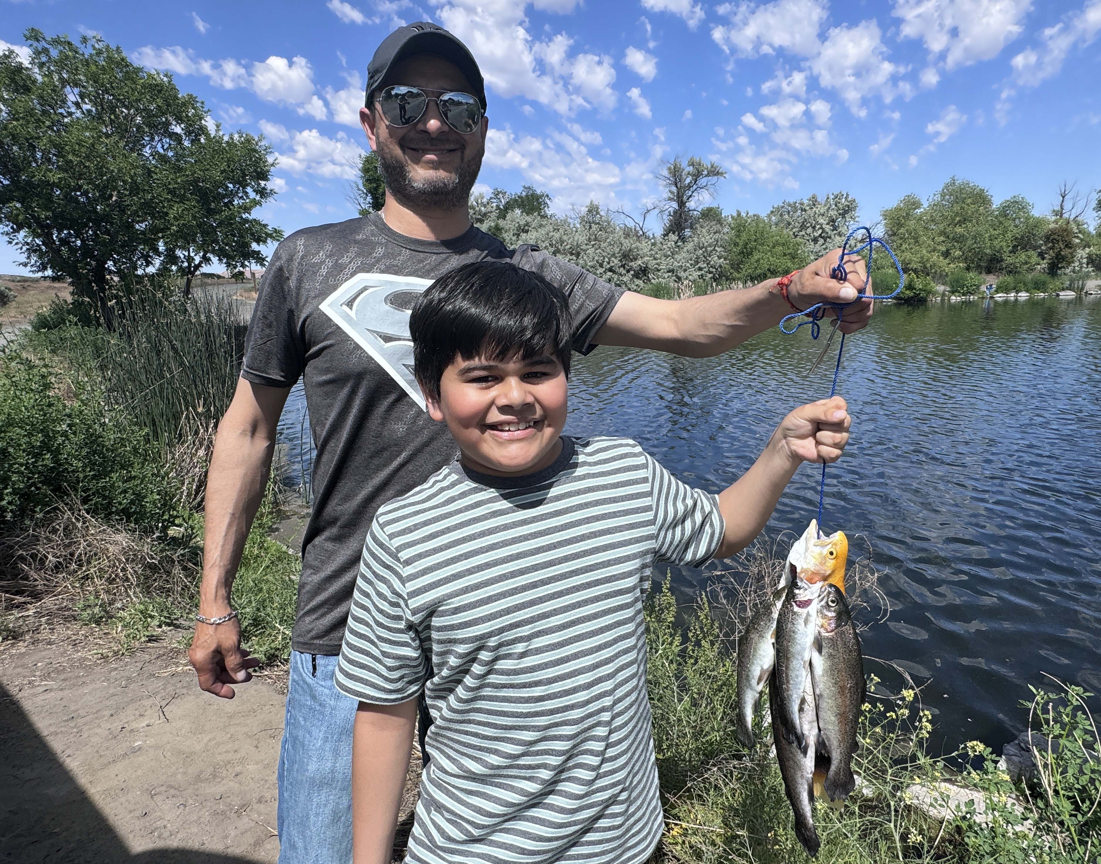 A young boy catches trout at Free Fishing Day at Riley Pond in Hagerman