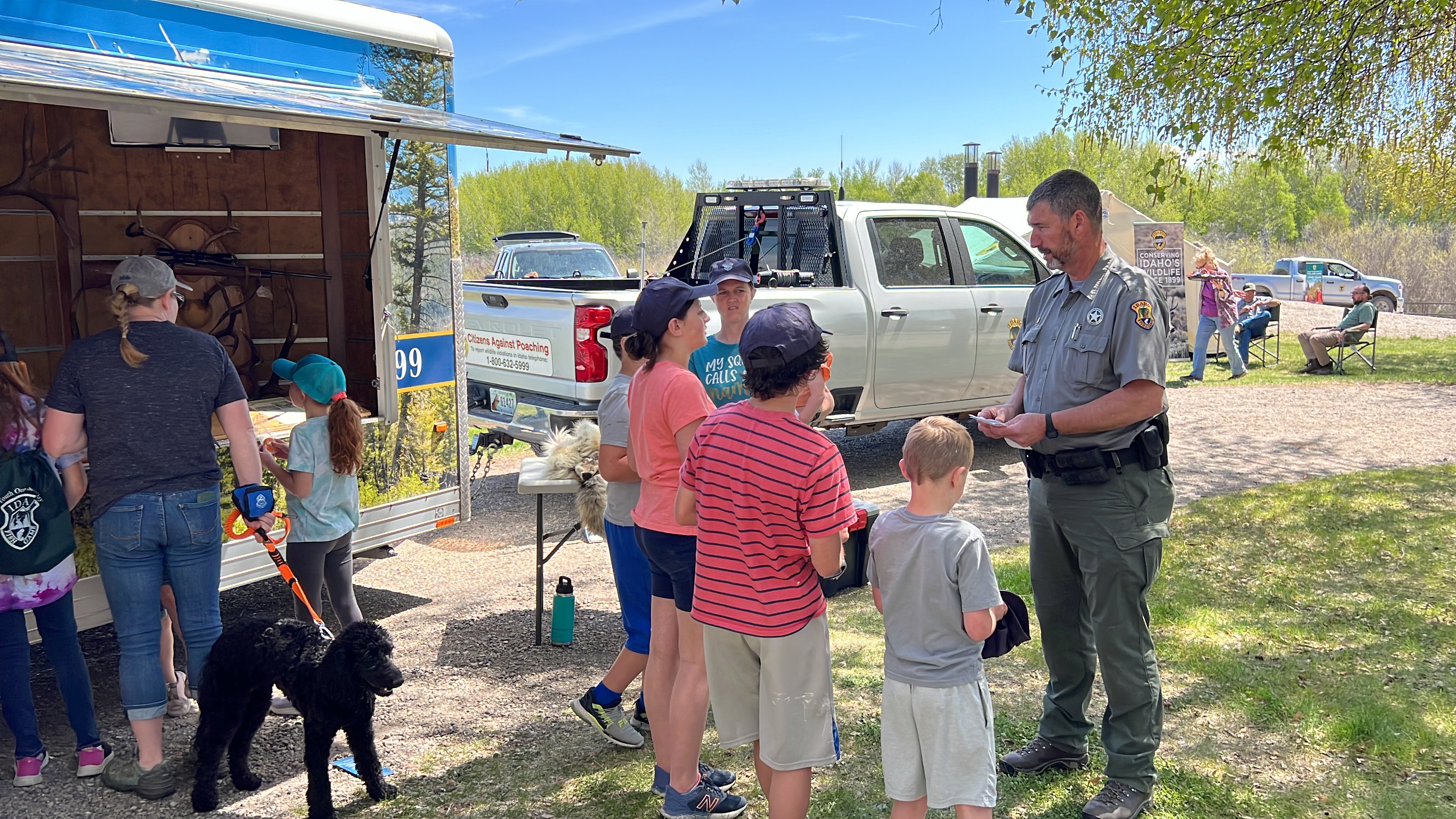 Conservation Officer teaching kids about the Citizens Against Poaching trailer.