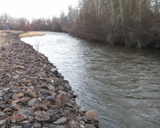 A straight river with banks made of large rocks