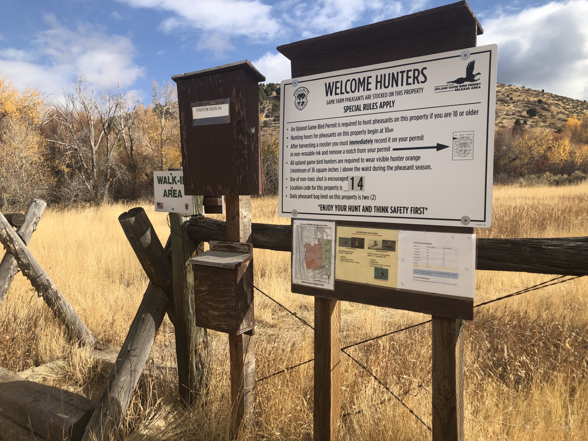 Signs with hunting information posted in open field with yellow fall grassses