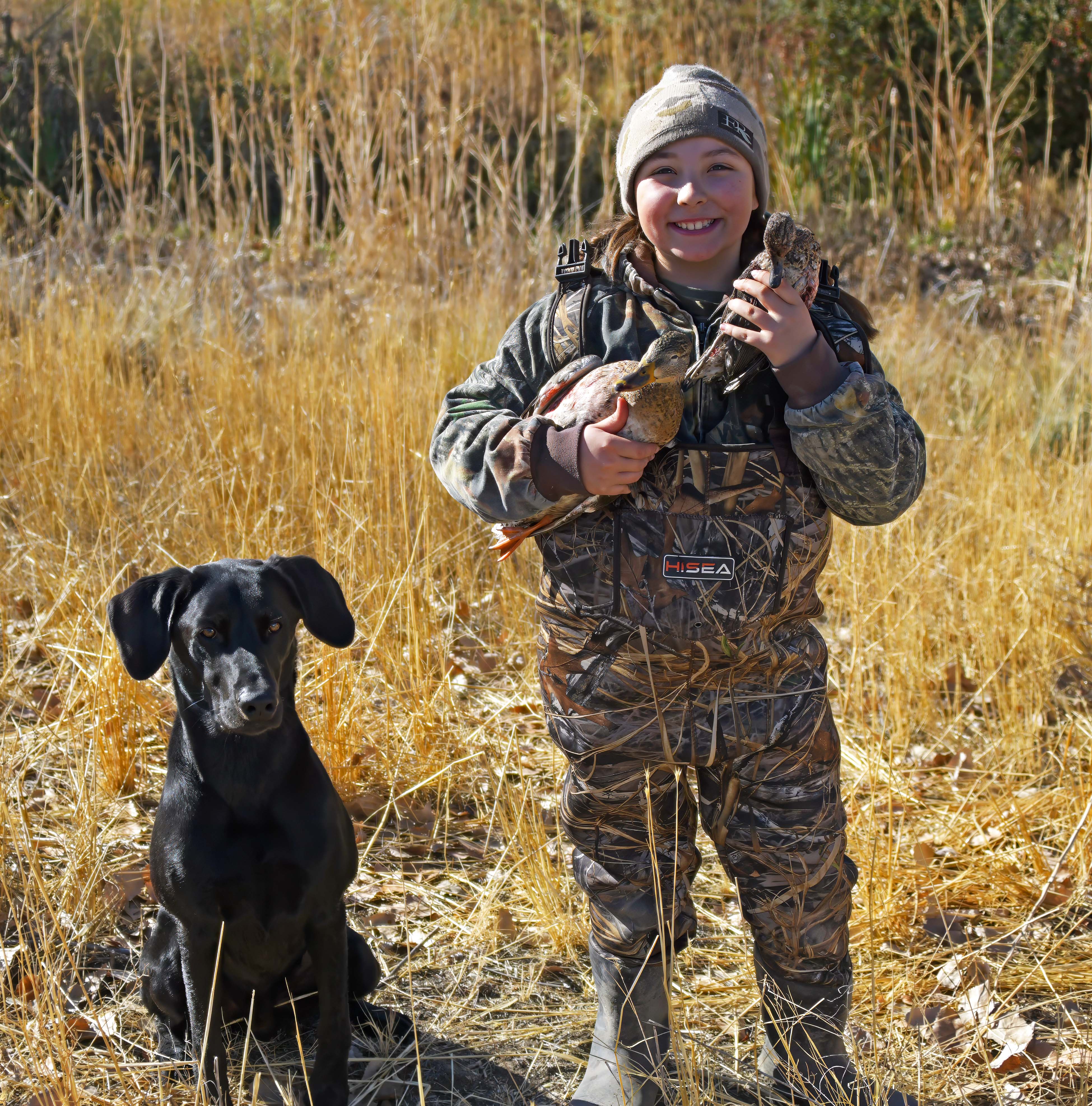 A young girl with her harvested ducks and retrieving dog at the mentored youth duck hunt Hagerman WMA