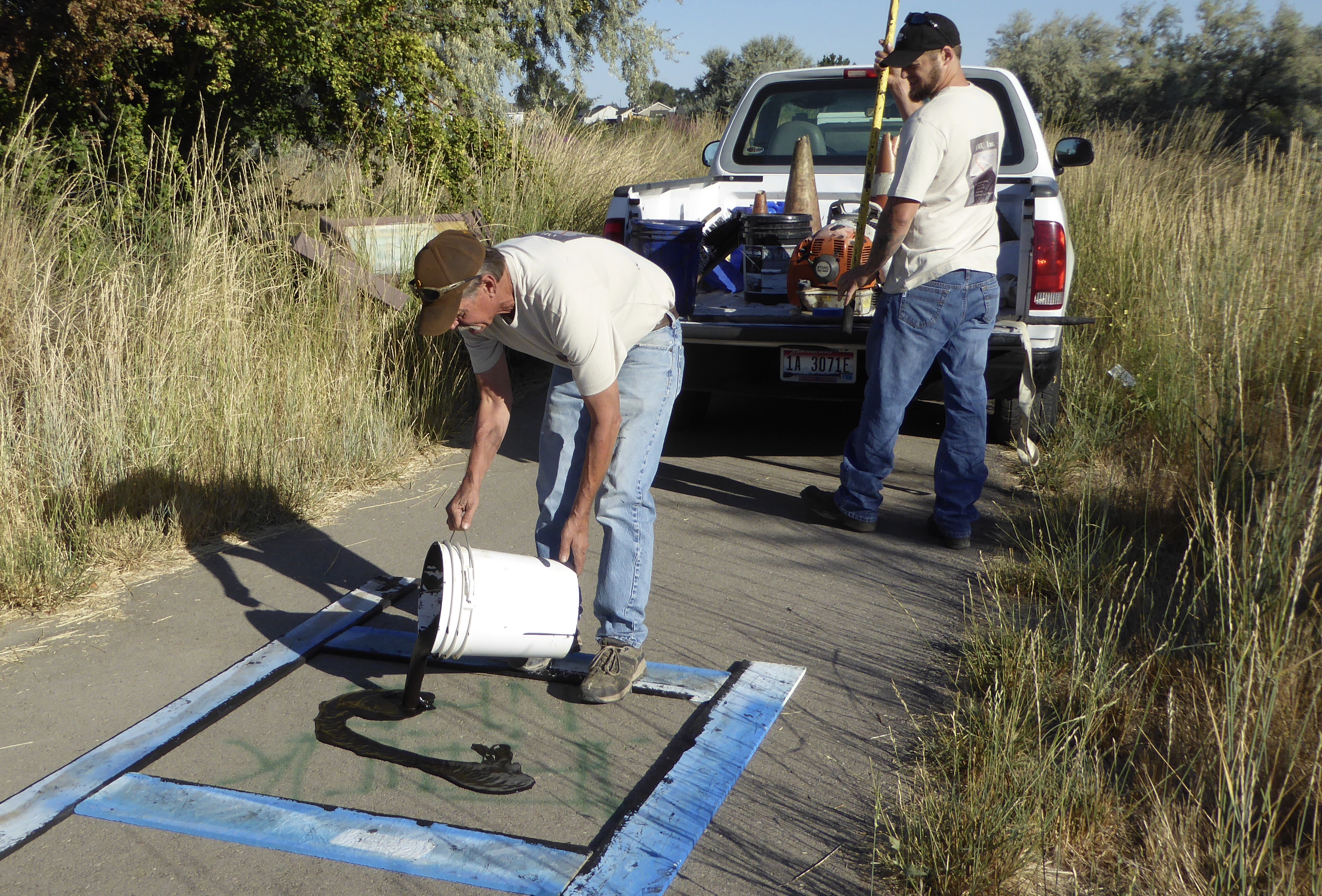 Volunteers Ron and Ross Carrico with AMU Inc. cover graffiti at Wilson Ponds in Nampa. 