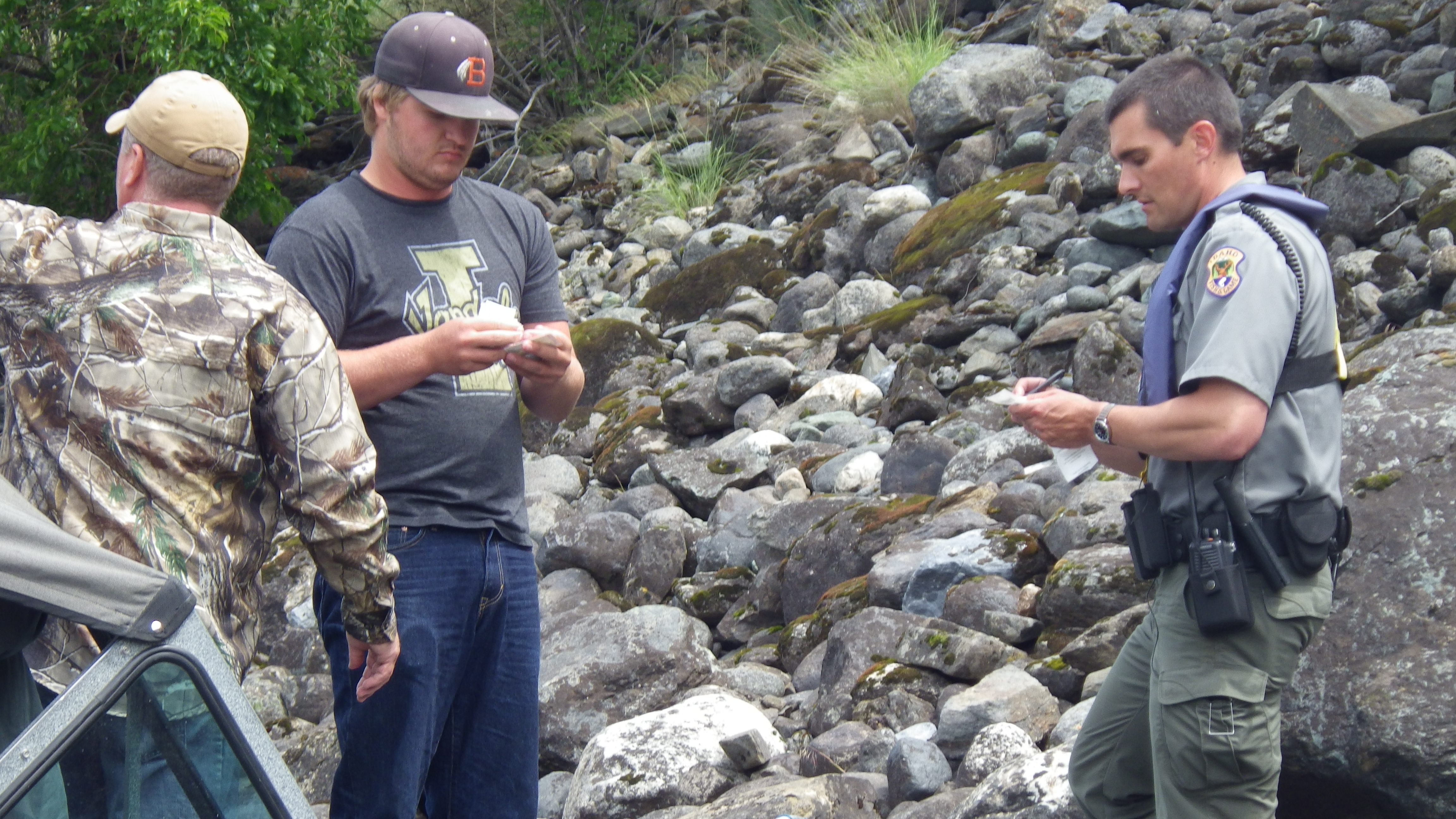 Salmon River Access an IDFG enforcement officer checks an anglers fishing license medium shot May 2015