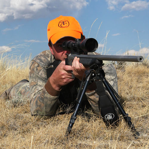 hunter shooter taking aim with his rifle and scope wearing a hunter orange cap April 2014