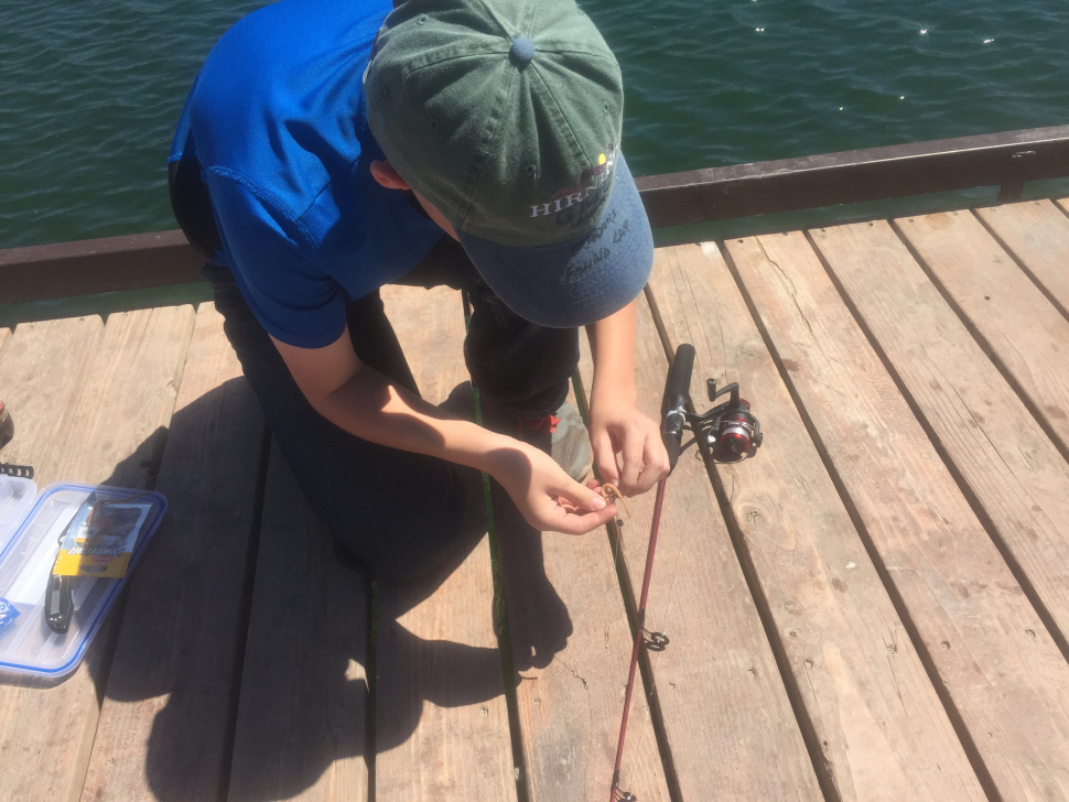 Edson Fichter Community Fishing Pond boy baiting his hook from a dock June 2015
