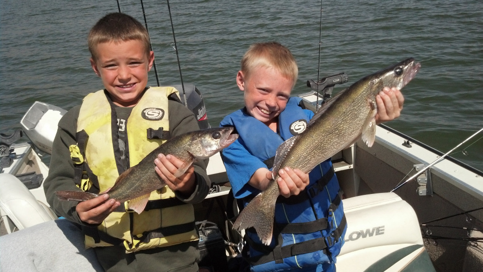 boys in a boat show off their walleye