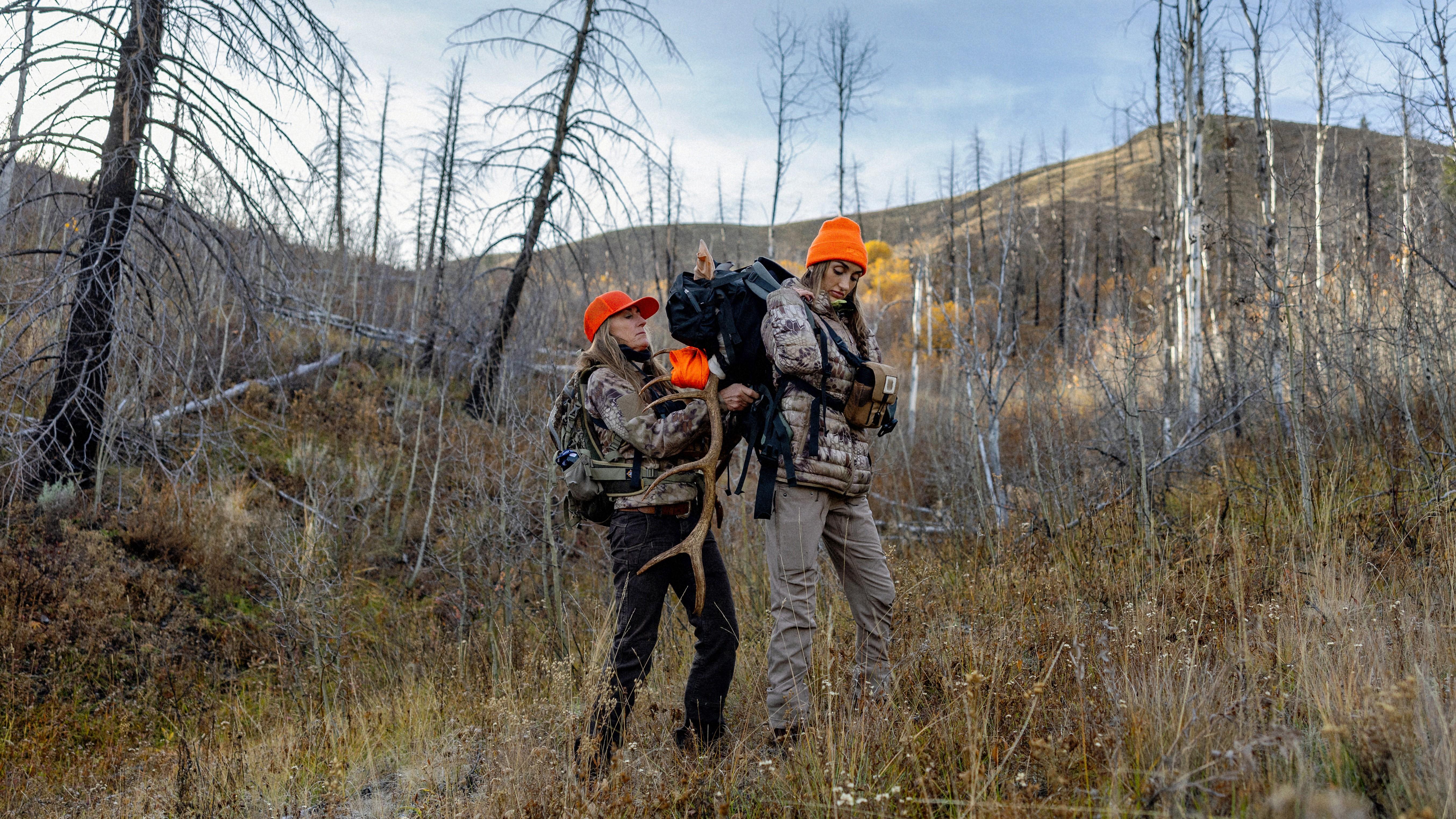 Mother and Daughter strapping elk antlers onto a backpack for a pack-out