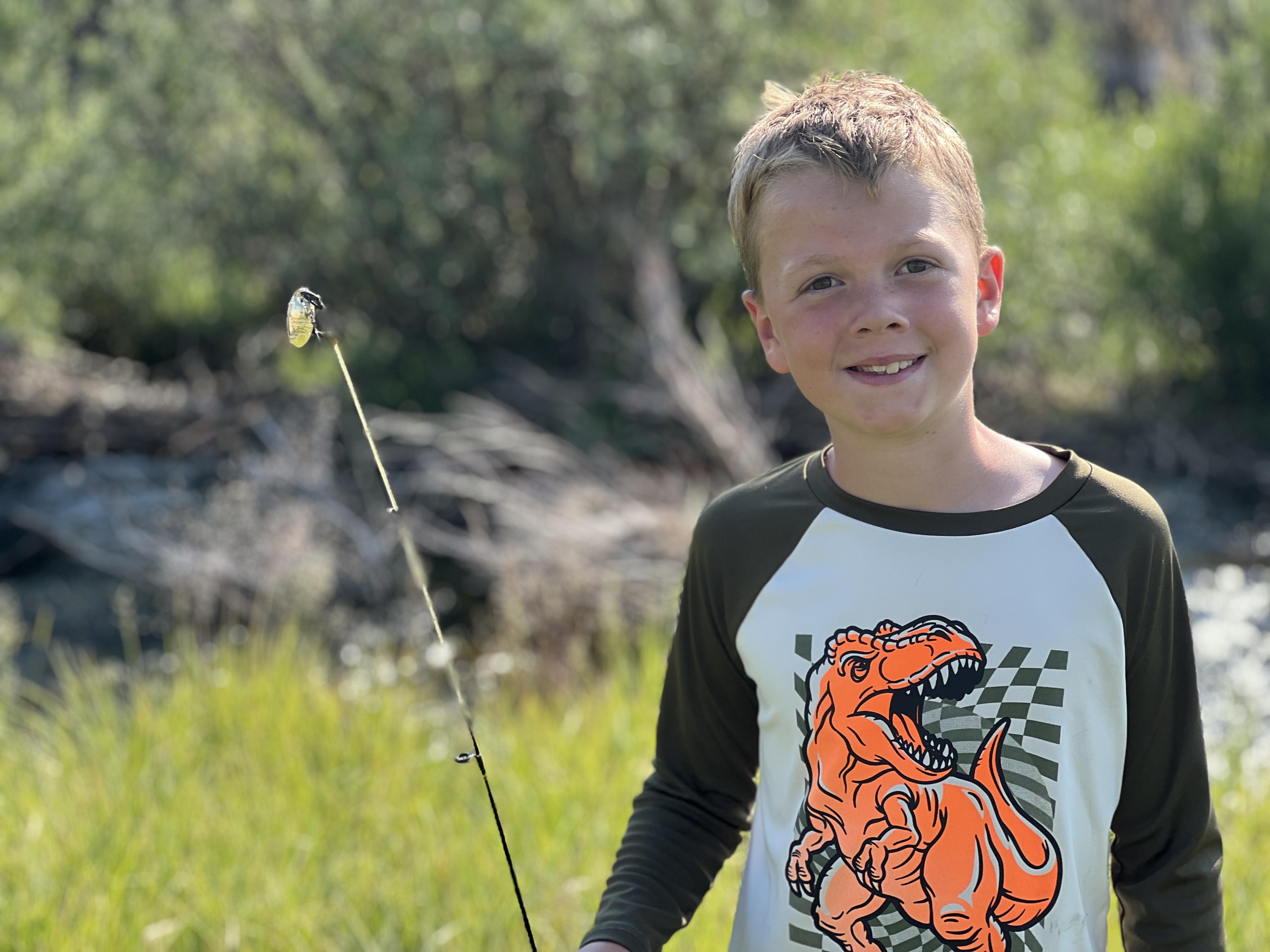 Smiling kid holding a fishing pole