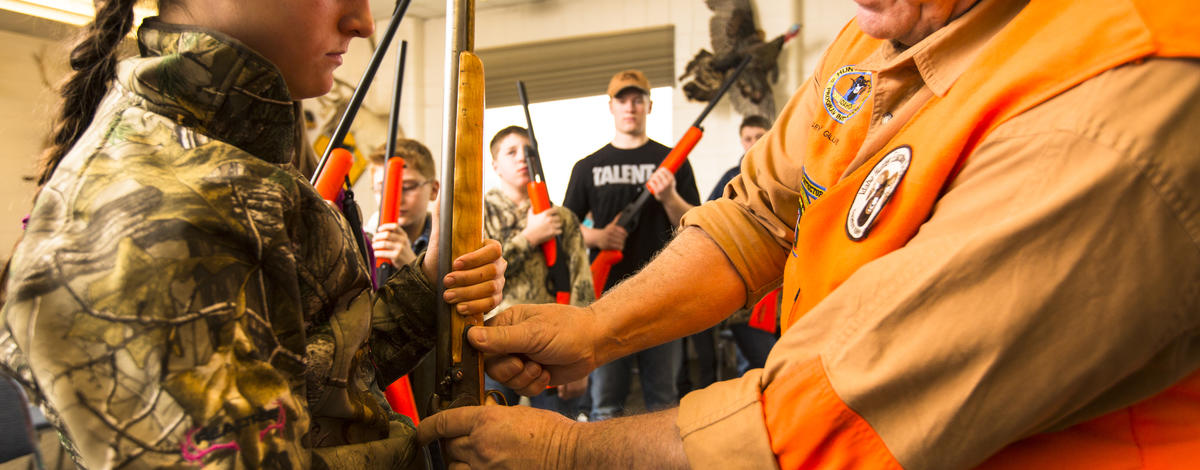 Gary Gillespie shows a girl at Hunter Education class how to use a rifle January 2014