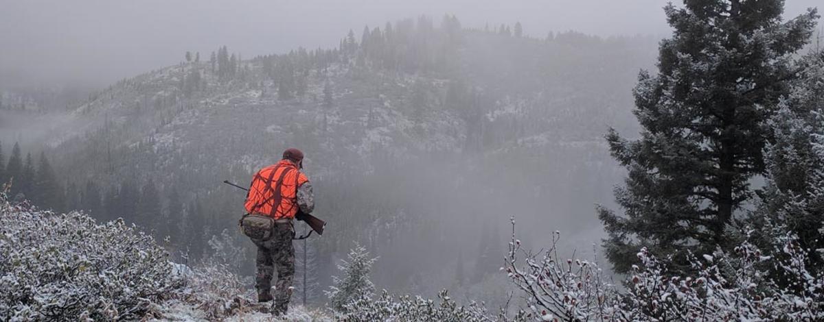 Big game hunter trailing deer in fog