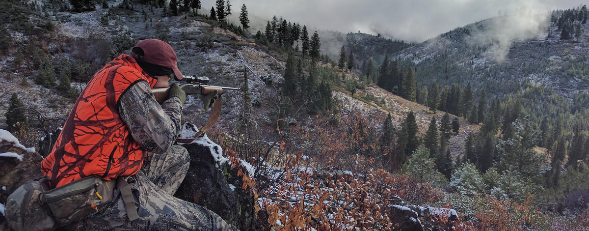 big game hunter dressed in hunter orange taking aim at an animal with his rifle Ben Studer medium shot, November 2016