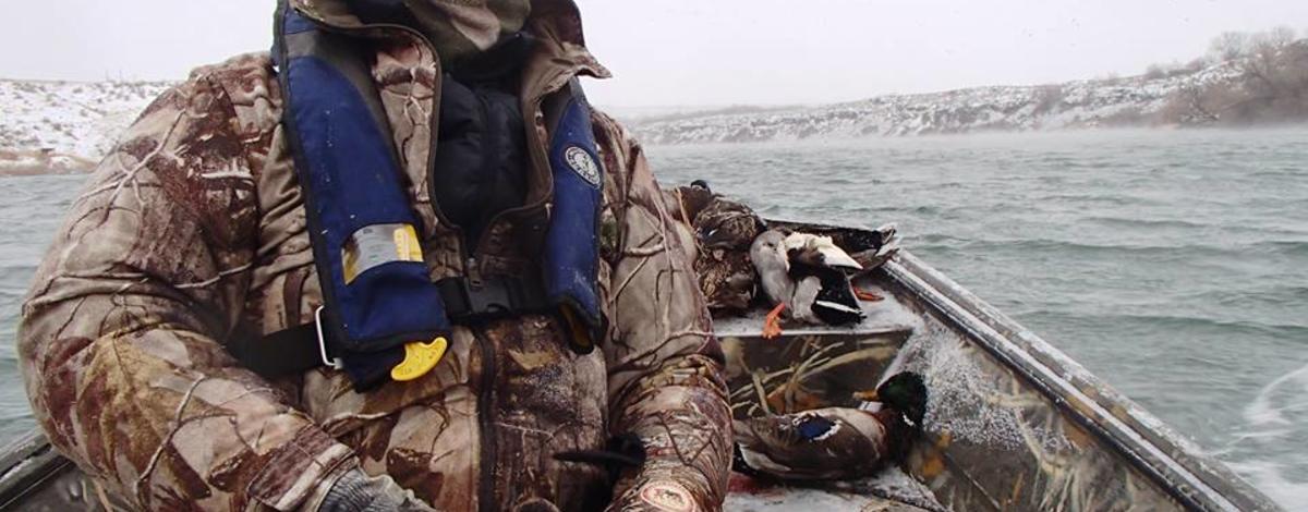 Photo of Duck hunter in boat in cold conditions