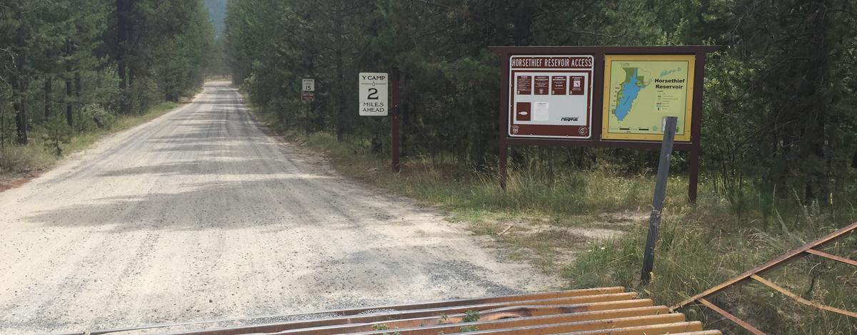 Horsethief  Reservoir Fishing Access cattle guard, informational signs, road medium shot August 2015