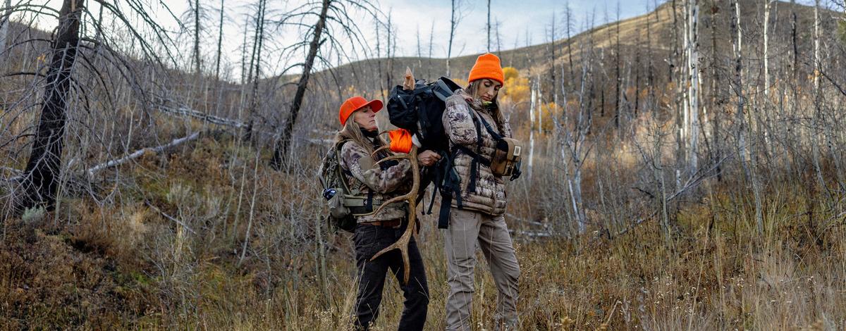 Mother and Daughter strapping elk antlers onto a backpack for a pack-out