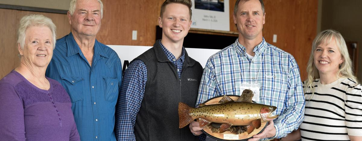 Brett High posing with family and holding his native trout conservation award