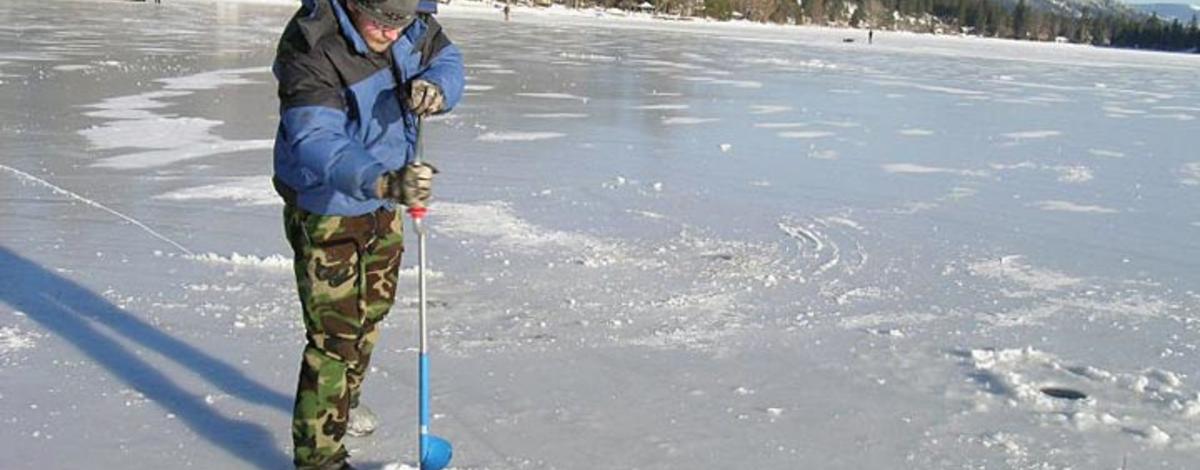 Using a hand auger to drill holes in the ice on Upper Twin Lake