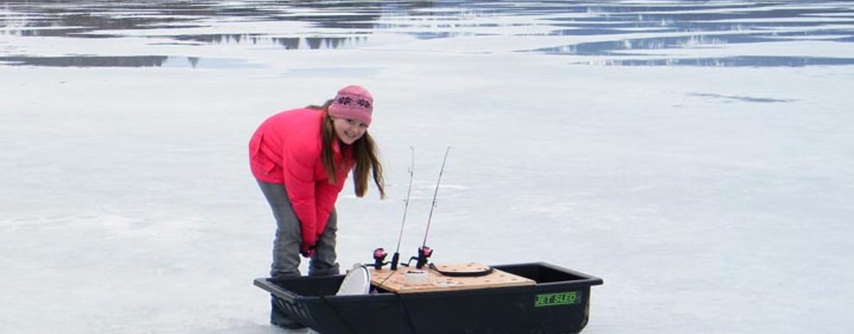 Pink girl, black sled - ice fishing in Panhandle of Idaho