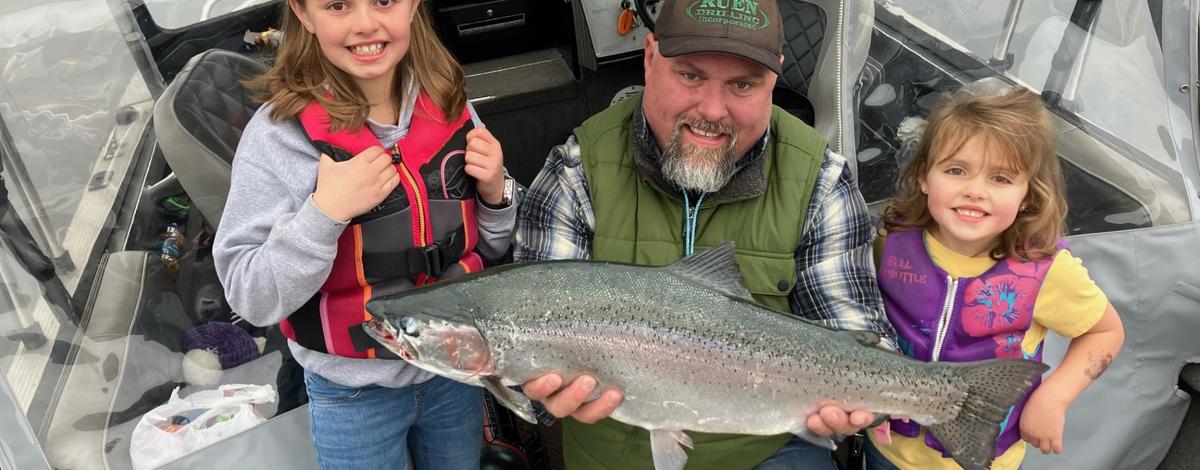 Anglers on Lake Pend Oreille with a rainbow trout