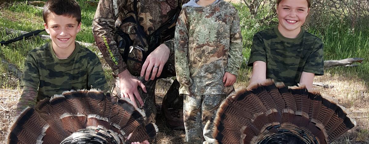 dad and kids with their two turkey during the youth turkey hunt 2015