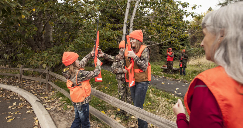 girls learning how to cross a fence with rifles on hunter education field day October 2015 