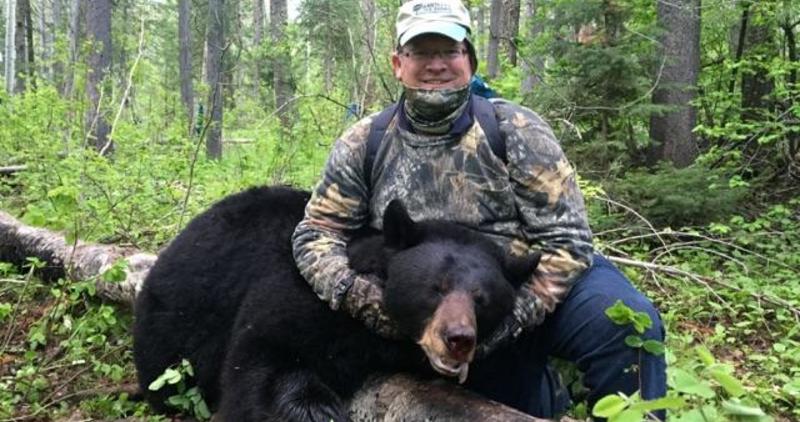 man with his black bear 