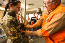 Gary Gillespie shows a girl at Hunter Education class how to use a rifle January 2014