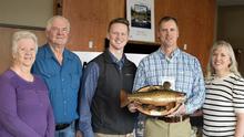 Brett High posing with family and holding his native trout conservation award