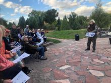 people watching a presenter standing in an outdoor amphitheater