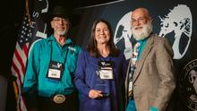 Hollie Miyasaki , Bill London, and Bruce Mincher on stage posing with Conservation Award
