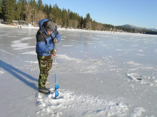 Using a hand auger to drill holes in the ice on Upper Twin Lake