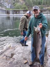 An angler holds a large Chinook salmon