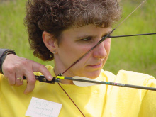 Patty using a bow and arrow during an archery demonstration June 2002
