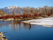 medium shot of an angler fishing on the South Fork of the Snake river in the Winter with snow on the river bank