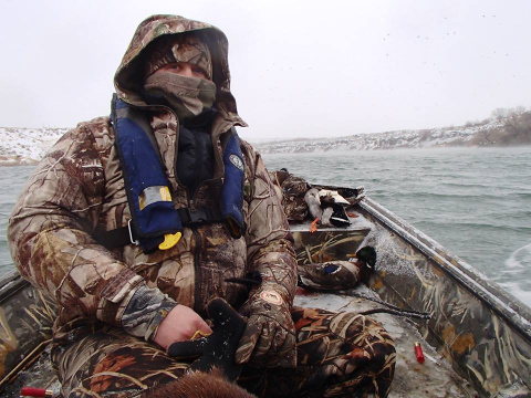 Photo of Duck hunter in boat in cold conditions